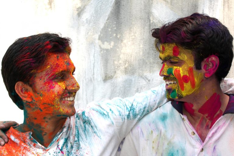 Two friends with faces covered in Holi powder