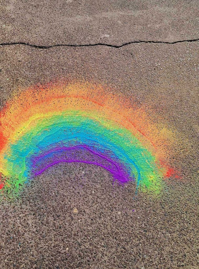Rainbow drawn on pavement with chalk powder